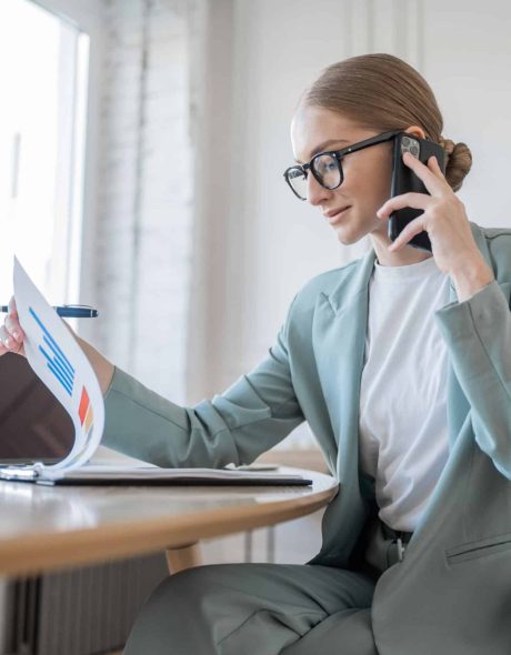 A woman with glasses is a freelancer who works, uses a laptop, makes a report to a finance company